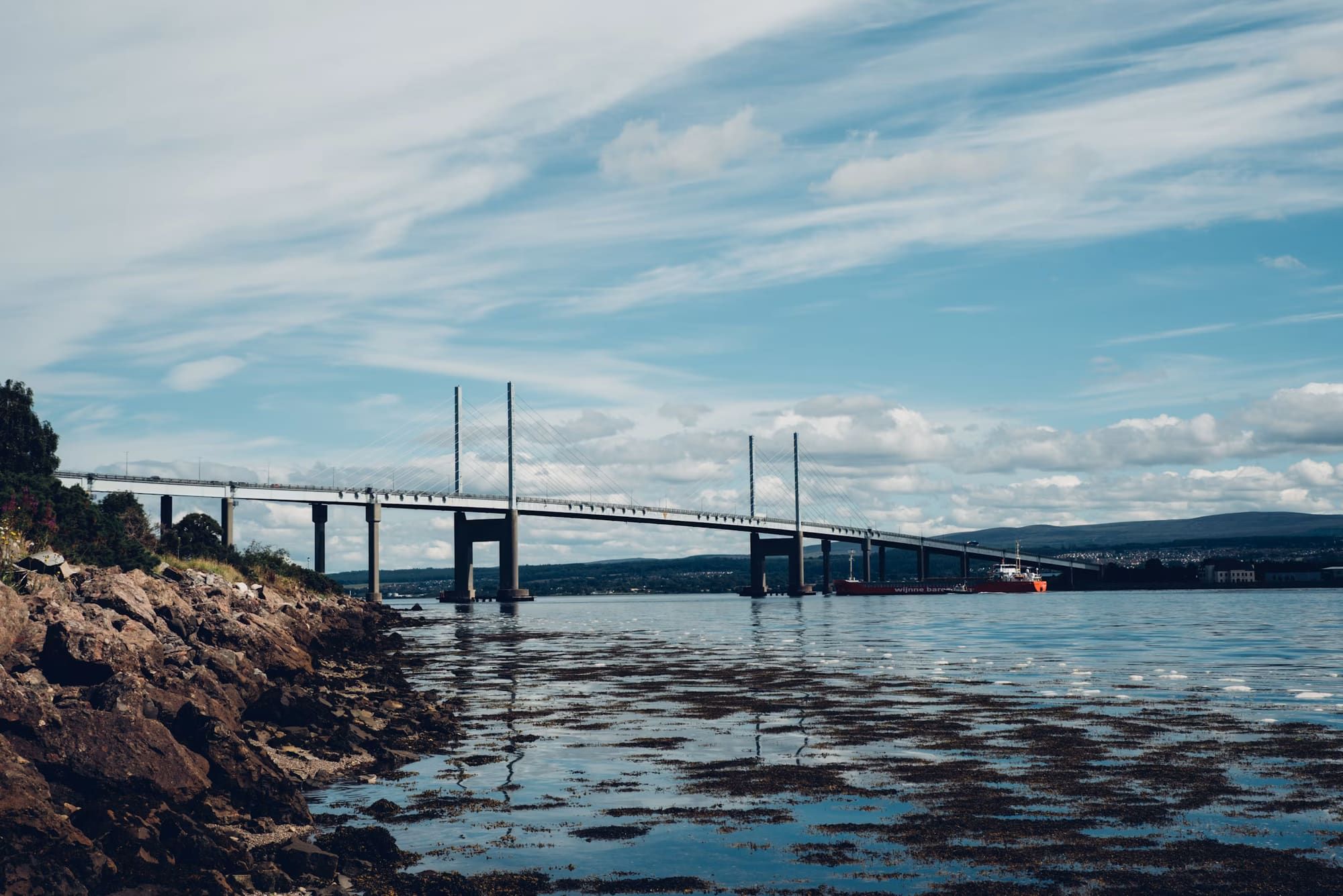 A long stone bridge crossing still water